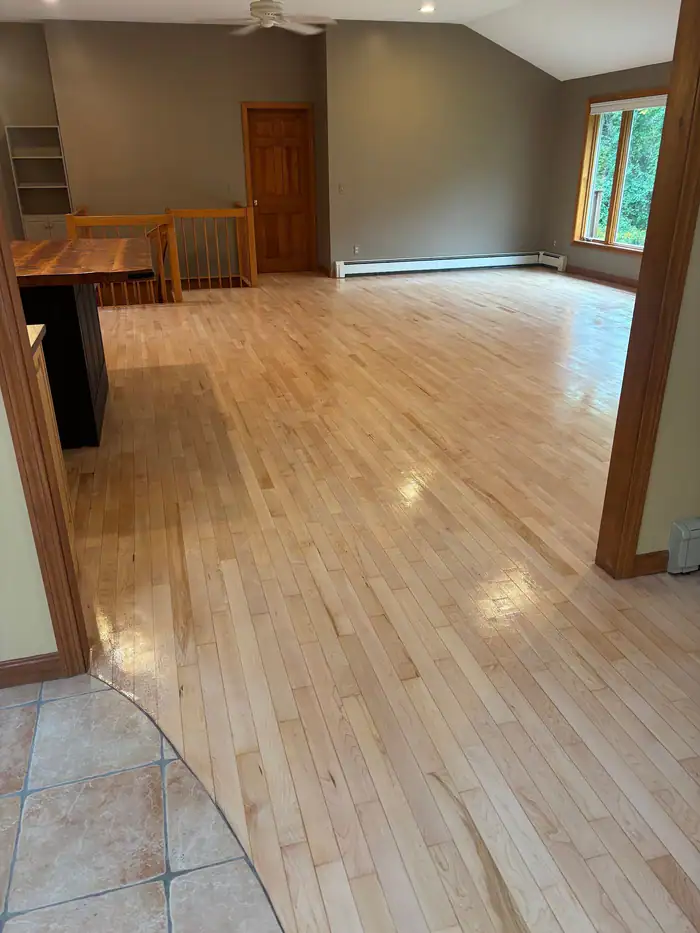 Natural oak floor in an open room with a tile entry