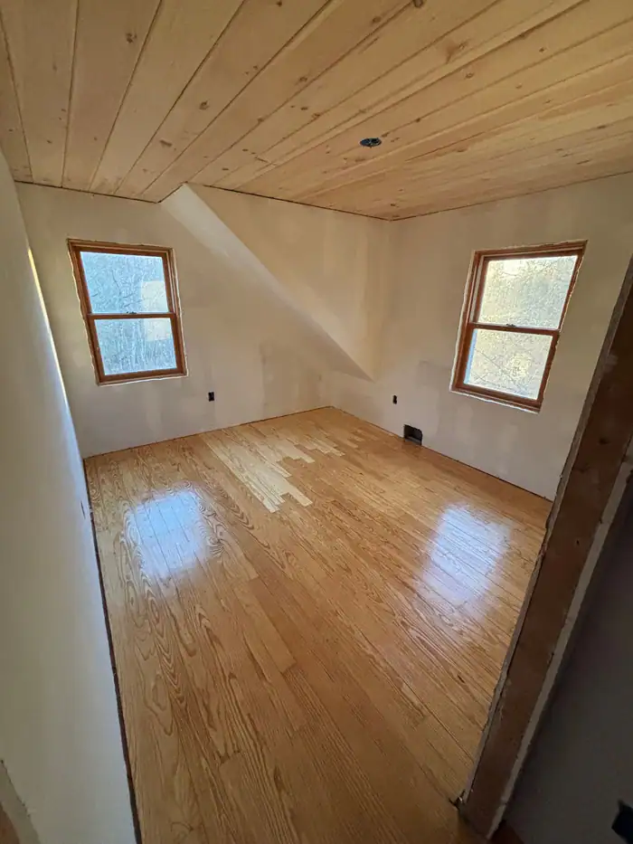 Oak floor refinished in a room with a pine board ceiling