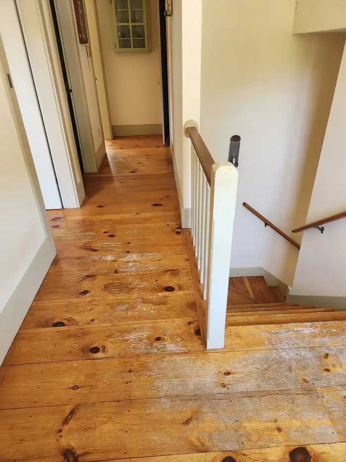 Pine boards at the top of a stair with a white railing