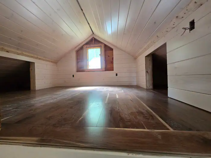 Dark glossy floor in a shiplap attic room