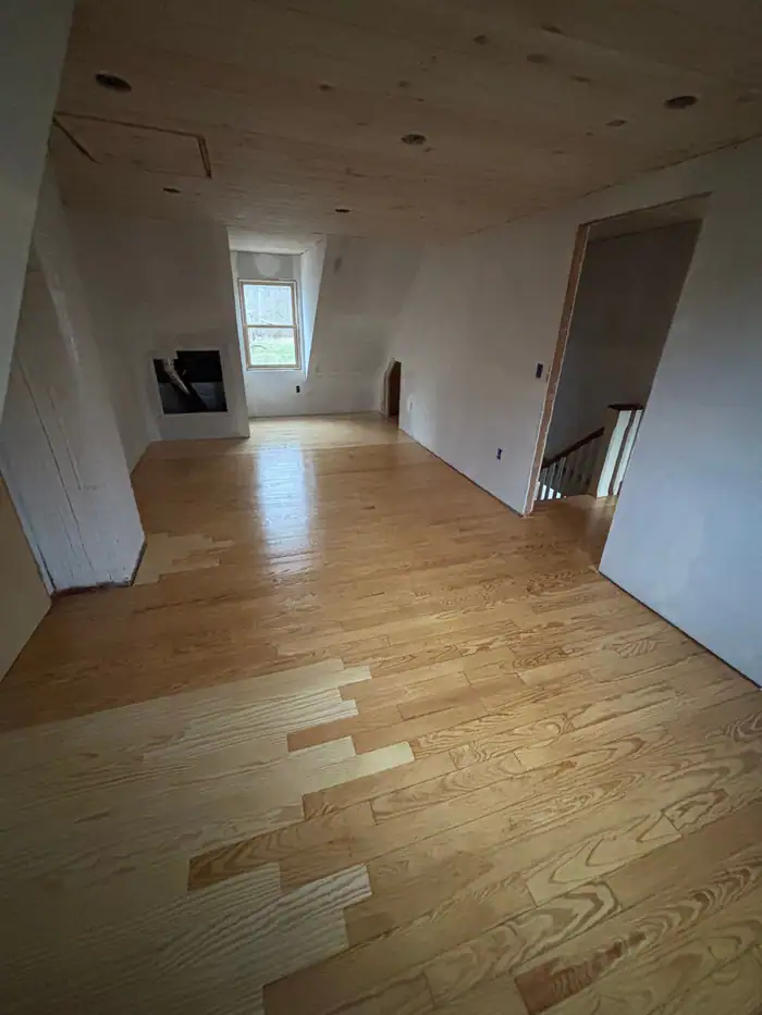 New oak boards woven into an older floor during a repair