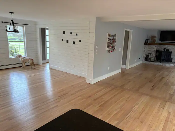 Oak floor through an open living area with a shiplap wall