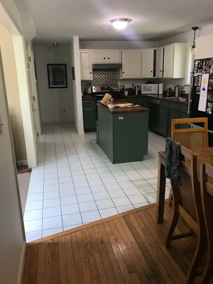 White tile kitchen floor meeting an oak floor at a clean edge