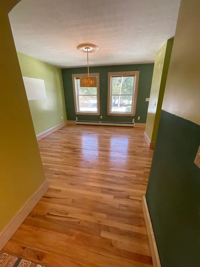 Glossy oak floor down a hallway with green walls