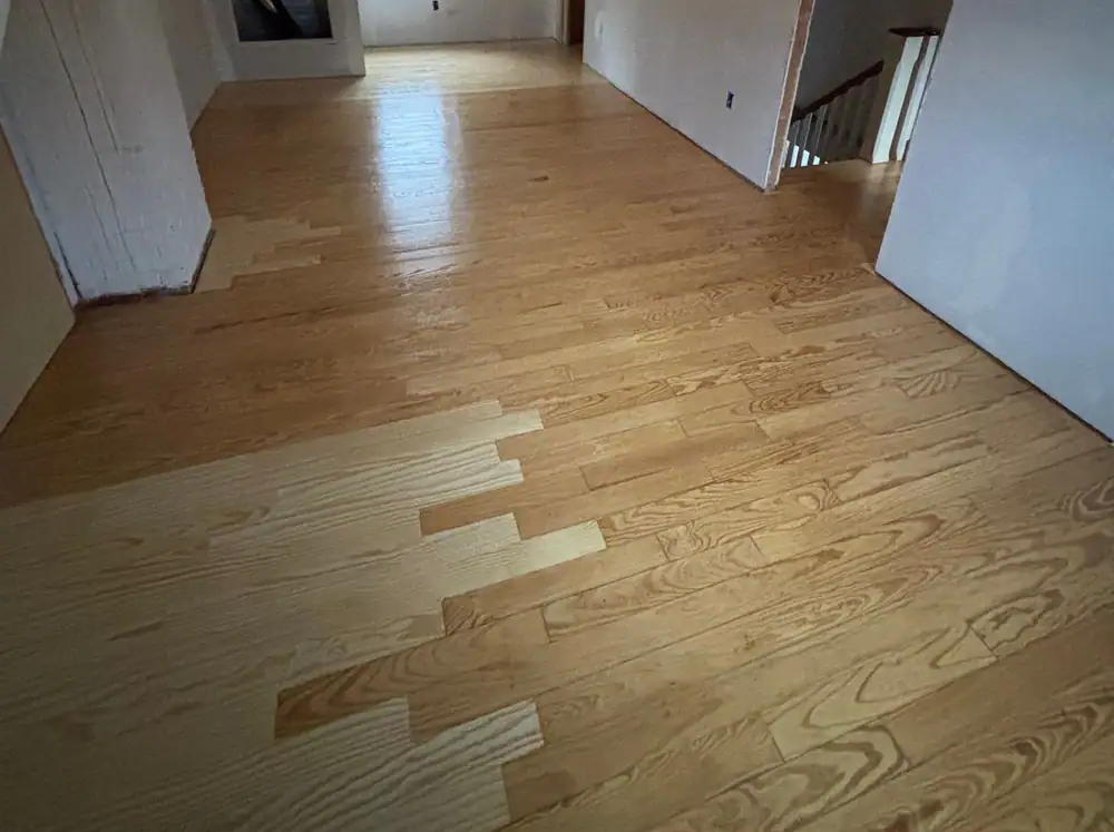 New oak boards woven into an older floor during a repair